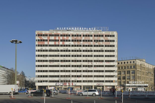 Ein leerstehendes Hochhaus, auf dem Dach ist die Bezeichnung "Allesandersplatz" montiert. Ein leerstehendes Hochhaus, auf dem Dach ist die Bezeichnung "Allesandersplatz" montiert.