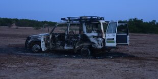 Ausgebrannter Geländewagen in der Savanne.