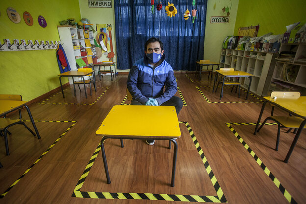 Ein Lehrer in einem Klassenraum mit Markierungen auf dem Fußboden.