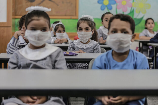 SchülerInnen in einem Klassenraum mit Mund-Nasenschutz.