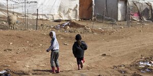 Zwei Kinder vor den Zelten eines Flüchtlingscamps.
