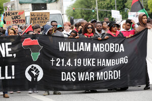 Menschen bei Protestkundgebung mit einem Banner in der Hand