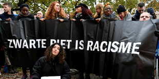 Protestierende mit einem Banner gegen den "Zwarten Piet"