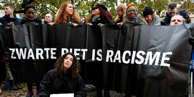 Protestierende mit einem Banner gegen den "Zwarten Piet"