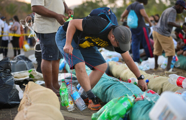 Freiwillige bauen eine Ölbarriere aus gefülltem Stoff