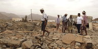 Jemeniten betrachten die Trümmer eines Hauses