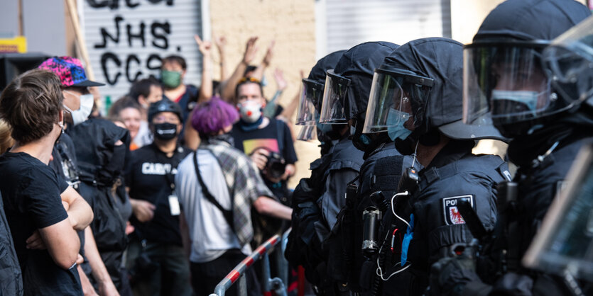 Demonstranten und Polizei stehen sich an einer Absperrung gegenüber