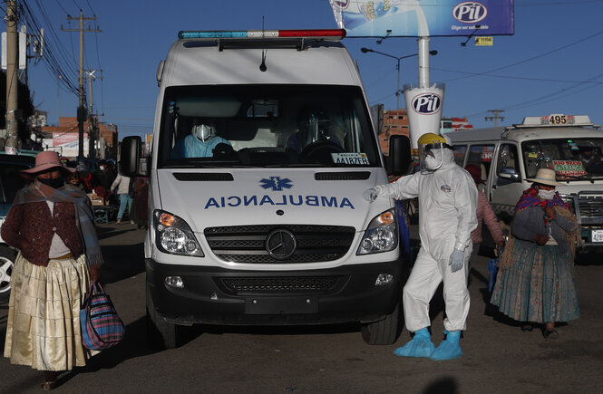 Krankenwagen und Helfer in Schutzkleidung.