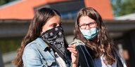 Zwei Schülerinnen einer 7. Klasse der Max-Schmeling-Stadtteilschule, unterhalten sich mit Mund-Nasen-Bedeckungen auf dem Schulhof.