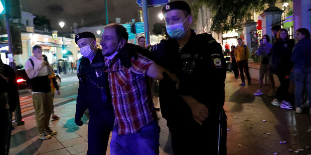 Ein Demonstrant wird von Polizisten festgenommen