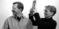 Ein historisches Foto von 2005: Jim Backer und Ilona Bubeck haben den Querverlag gegründet - fürs Foto haut sie ihren Kollegen gespielt eins mit dem Buch auf den Kopf