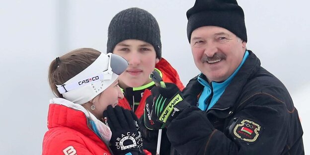 Weißrusslands Präsident mit Wollmütze gratuliert einer Biathletin