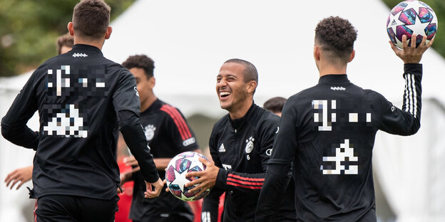 Vier Bayernspieler lachen beim Training mit den Ball in der Hand