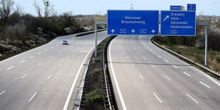 Ein einzelnes Auto auf einer ansonsten leeren Autobahn.