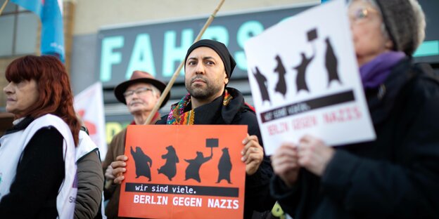 Ferat Kocak hält bei einer Soli-Demo ein Schild auf dem "Berlin gegen Nazis" steht