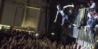Der Gitarrist der Band Lauter als Bombe springt in die Menge im Musikclub Huxleys Neuer Welt