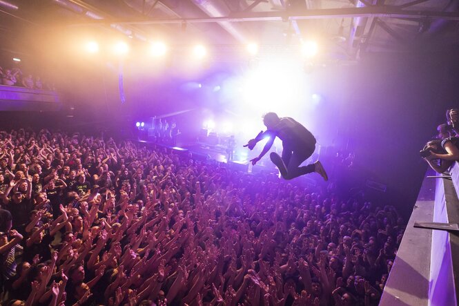 Eine Konzerthalle voller Menschen: Sänger Ingo Knollmann von der Band Donots springt