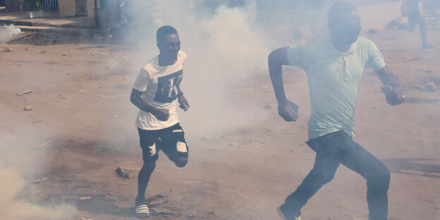 Demonstranten rennen im Tränengasnebel