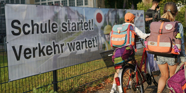 Kinder mit Schulranzen auf dem Weg zur Schule