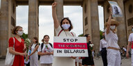 Eine Frau hält ein Schild mit der Aufschrift "Stop the Violence in Belarus"