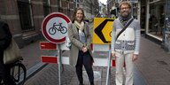 Ein Mann und eine Frau stehen vor Stop-Schildern auf einer Amsterdamer Straße