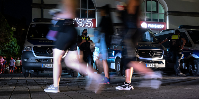 Passanten gehen in der Altstadt an Polizisten vorbei