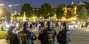 Vier Polizist*innen im Vordergrund, dahinter Park und Gruppen von Jugendlichen