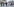 Polizisten und leger gekleidete Menschen auf einem breiten Bürgersteig, im Hintergrund der Triumpfbogen