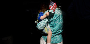Eine Frau wartet mit ihrer Tochter auf dem Arm auf Rick Santorum