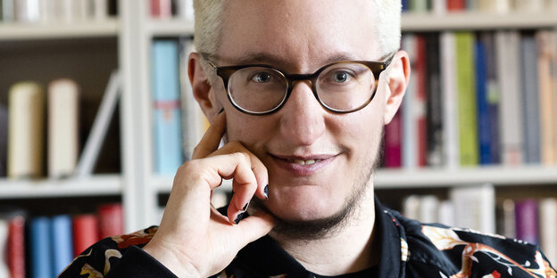Porträt des Autors Linus Giese vor einem Bücherregal