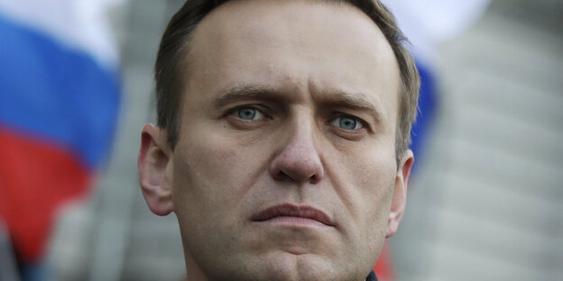 Porträt von Alexej Nawalny vor einer russischen Fahne