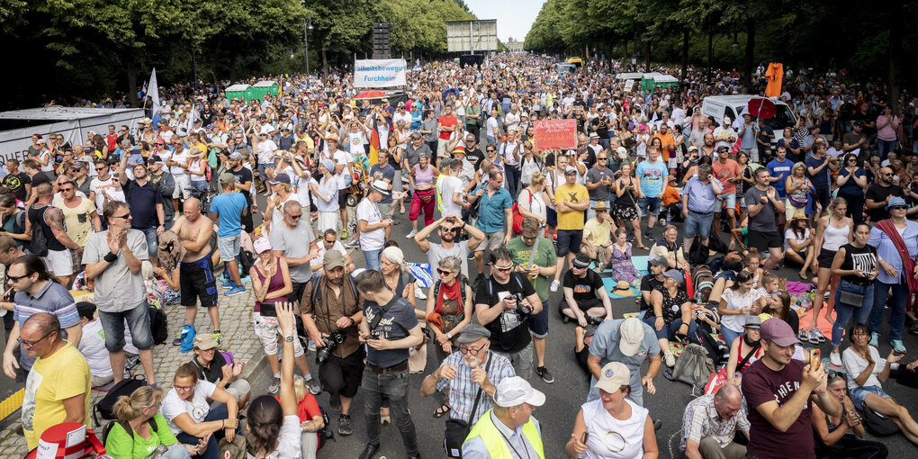 Dicht gedrängt und ohne die Abstandsregeln zu beachten stehen Tausende bei einer Kundgebung gegen die Corona-Beschränkungen auf der Straße des 17. Juni.