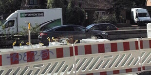 Baustelle an einer Straße, im Hintergrund fahrende Autos