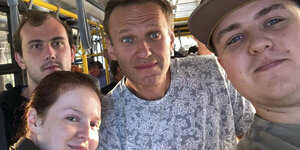 Der Kremlkritiker Nawalny posiert mit zwei jungen Männern und seiner Sprecherin für ein Selfie in einem Bus