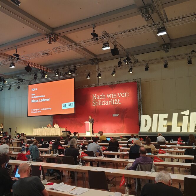 Menschen sitzen in einem großen Saal auf einem Parteitag