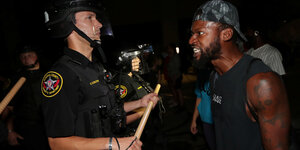 Ein Demonstrant und ein Polizist stehen sich gegenüber.