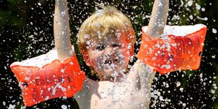 Ein Junge mit Schwimmflügeln.