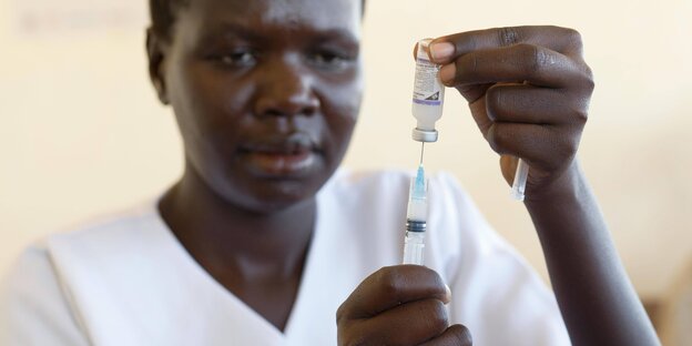 Eine Krankenschwester zeiht eine Impfspritze auf.