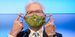 Winfried Kretschmann mit grüner Alltagsmaske