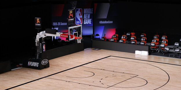 Ein leeres Baskettballfeld in einer Halle.