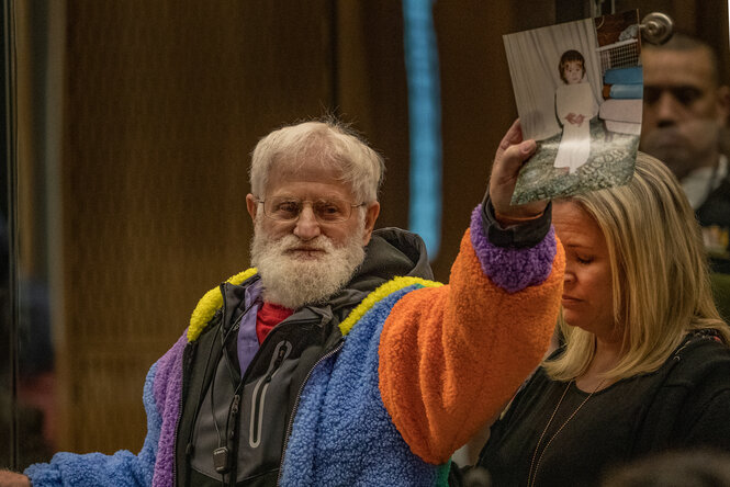 John Milne hält ein Foto seiner ermordeten Tochter hoch