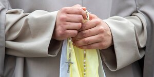 Eine Nonne hält einen Rosenkranz in den Händen, Detailfoto