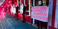 Sexarbeiter:innen halten Protestschilder hoch