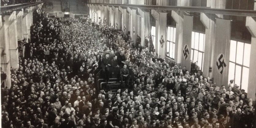 Arbeiter beim Betriebsappell mit Hakenkreuzflaggen bei Continental im Mai 1942