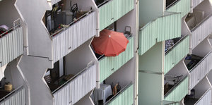 Orangefarbener Sonnenschirm auf einem Balkon eines Wohnhochhauses