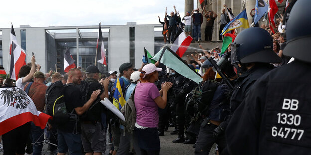 Polizisten sprühen Pfefferspray in die Menge vor dem Reichstag