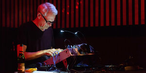 Der elektronische Musiker Frank Bretschneider steht an einem Synthesizer