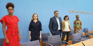 Fünf Menschen stehen vor der blauen Wand der Bundespressekonferenz