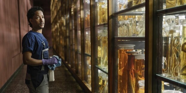 Kiflom Melake vor Vitrine mit eingeweckten Tieren im Berliner Naturkundemuseum