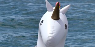 Ein aufblasbares Einhorn schwimmt auf dem Meer